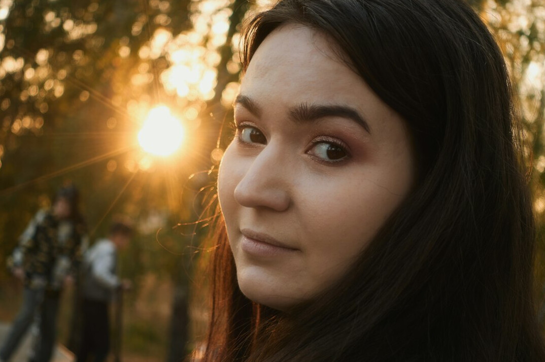 Portrait of a young woman with dark hair smiling warmly